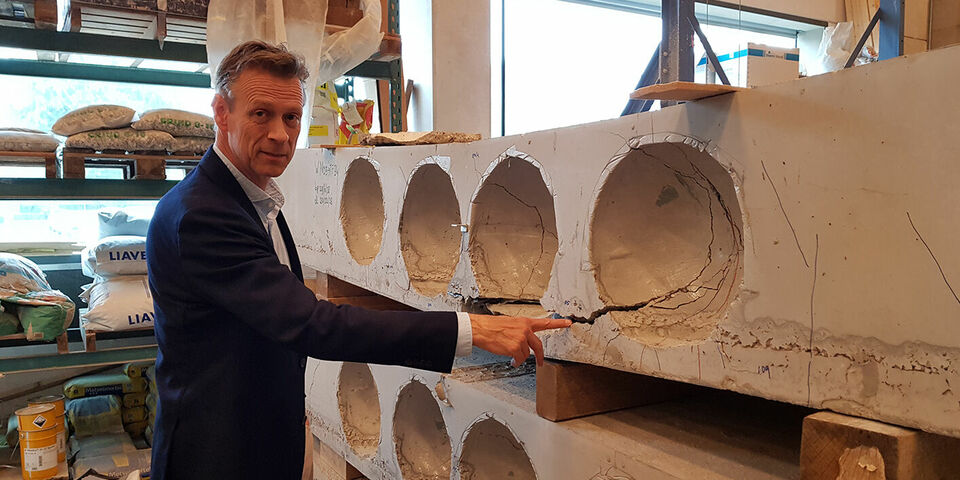 Simon Wijte in het lab van Bouwkunde bij een onderzochte proefplaat. Foto | Han Konings