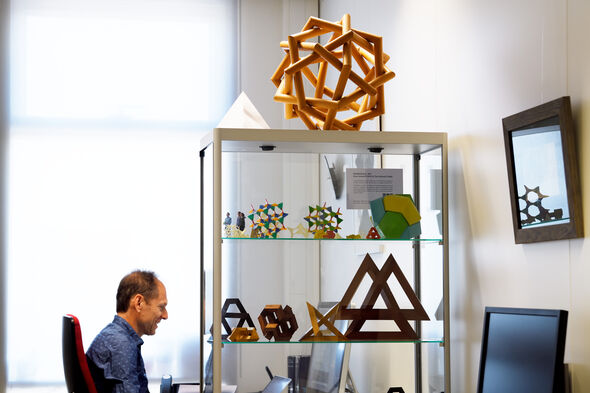 Tom Verhoeff met op de voorgrond houten objecten van zijn vader Koos. Foto | Bart van Overbeeke